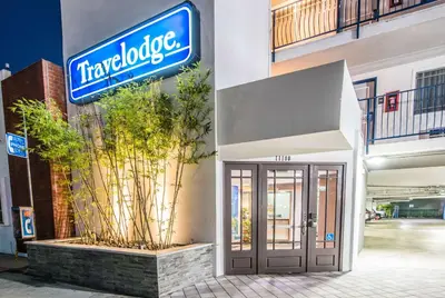 a sign on the side of a building with a door at Travelodge by Wyndham Culver City in Los Angeles