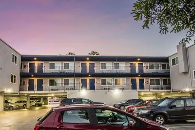 a parking lot with cars parked in front of a building at Travelodge by Wyndham Culver City in Los Angeles