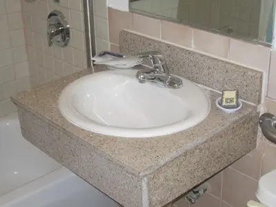 a bathroom sink with a granite counter top at Apache Inn in Lynwood