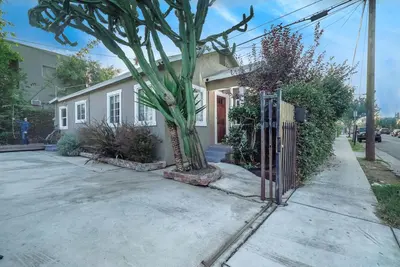 a house with a tree in front of a driveway at Stylish 2 Bed & 2 Bath at the Heart of Hollywood with Free Parking - One Car only in Los Angeles