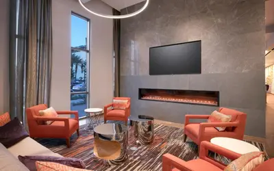 a living room with orange chairs and a fireplace at Hampton Inn & Suites Anaheim Resort Convention Center in Anaheim