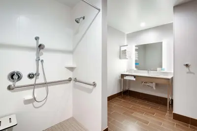 a bathroom with a shower and a sink at Hampton Inn & Suites Anaheim Resort Convention Center in Anaheim