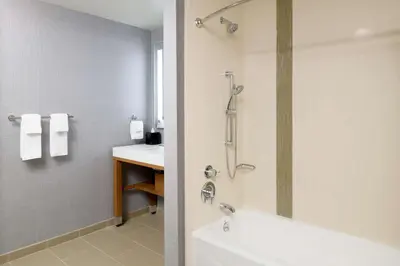 a bathroom with a shower and a white tub at Hyatt Place Pasadena in Pasadena