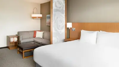 a hotel room with a bed and a chair at Hyatt Place Pasadena in Pasadena