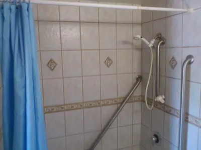 a shower with a blue shower curtain in a bathroom at Santa Ana Travel Inn in Santa Ana