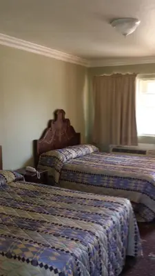 a hotel room with two beds and a window at Santa Ana Travel Inn in Santa Ana
