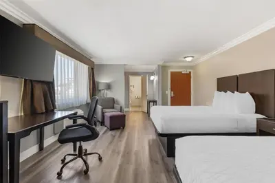 a hotel room with two beds and a desk at Best Western Plus LA Mid-Town Hotel in Los Angeles