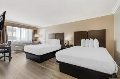 a hotel room with two beds and a desk at Best Western Plus LA Mid-Town Hotel in Los Angeles