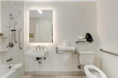 a bathroom with a toilet and a sink and a mirror at Best Western Plus LA Mid-Town Hotel in Los Angeles