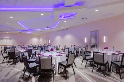 a banquet hall with tables and chairs and purple lighting at Holiday Inn La Mirada Buena Park by IHG in La Mirada