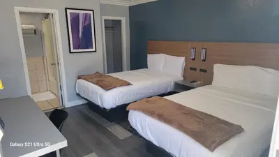 two beds in a hotel room with two beds sidx sidx sidx at Value Inn Hollywood in Los Angeles