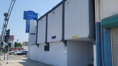 a building with a street sign on the side of it at Value Inn Hollywood in Los Angeles
