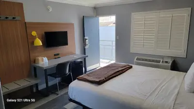 a bedroom with a bed and a desk with a computer at Value Inn Hollywood in Los Angeles