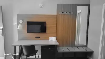 a bathroom with a desk and a tv and a mirror at Value Inn Hollywood in Los Angeles