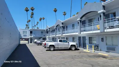 a white truck parked in a parking lot next to a building at Value Inn Hollywood in Los Angeles