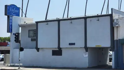 a white building with a sign on the side of it at Value Inn Hollywood in Los Angeles