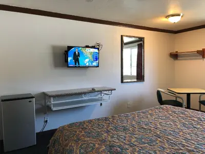 a hotel room with a bed and a tv on the wall at Starlight Inn, Valley Blvd - Downtown LA in Los Angeles