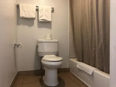 a bathroom with a toilet and a shower with towels at Starlight Inn, Valley Blvd - Downtown LA in Los Angeles