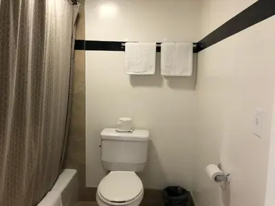 a bathroom with a toilet and a shower with towels at Starlight Inn, Valley Blvd - Downtown LA in Los Angeles
