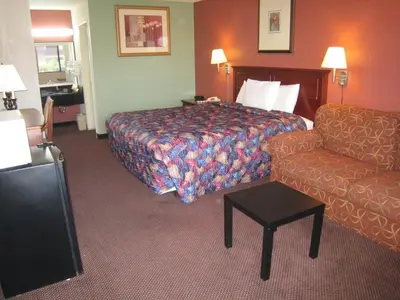 a hotel room with a bed and a couch at Motel 8 Maricopa in Maricopa