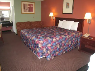 a hotel room with a bed and a couch at Motel 8 Maricopa in Maricopa