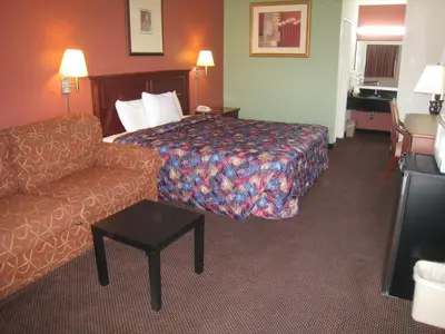 a hotel room with a bed and a couch at Motel 8 Maricopa in Maricopa