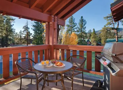 a table and chairs on a deck with a grill at WorldMark Big Bear Lake in Big Bear Lake