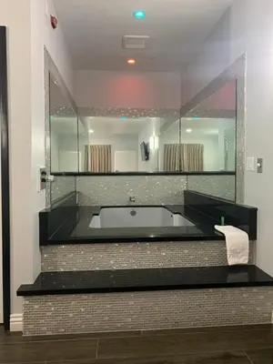a bathroom with a tub and a large mirror at Crescent Inn in Wilmington