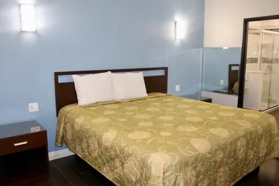 a bedroom with a bed with a green comforter at Crescent Inn in Wilmington