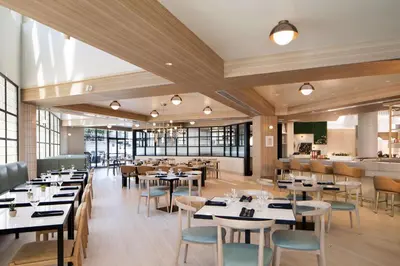 a restaurant with tables and chairs and a bar at Hilton Santa Monica in Los Angeles