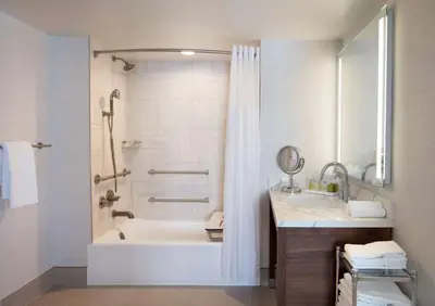 a bathroom with a tub and a sink and a shower at Hilton Santa Monica in Los Angeles
