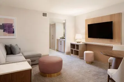 a living room with a couch and a flat screen tv at Hilton Santa Monica in Los Angeles