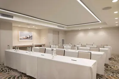 a large room with white tables and chairs at Hilton Santa Monica in Los Angeles
