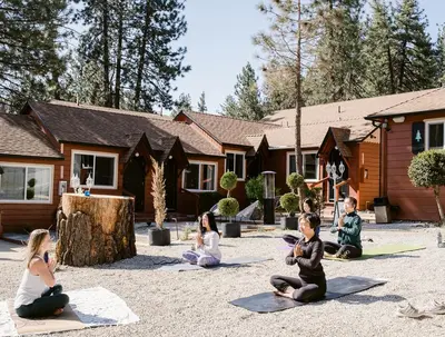 a group of people sitting in a circle in front of a house at Grand Pine Cabins in Wrightwood