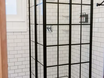 a shower with black glass shelves in a bathroom at Grand Pine Cabins in Wrightwood