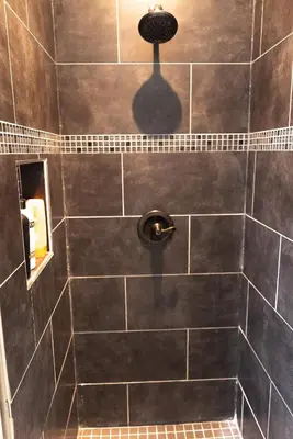 a bathroom with a shower with a black tiled wall at Cozy private Guest House in Los Angeles