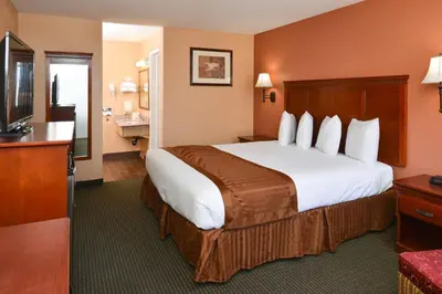 a hotel room with a large bed and a television at Americas Best Value Inn & Suites-East Bakersfield in Bakersfield