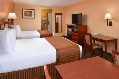 a hotel room with two beds and a desk at Americas Best Value Inn & Suites-East Bakersfield in Bakersfield