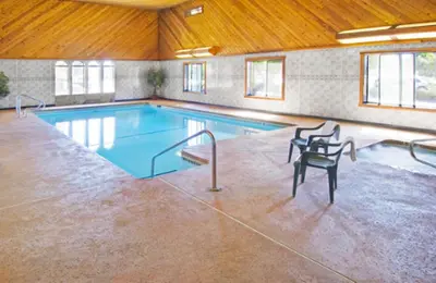 a large swimming pool with two chairs next to it at Americas Best Value Inn & Suites-East Bakersfield in Bakersfield