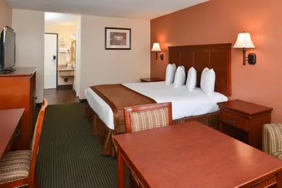 a hotel room with a bed and a dining room at Americas Best Value Inn & Suites-East Bakersfield in Bakersfield