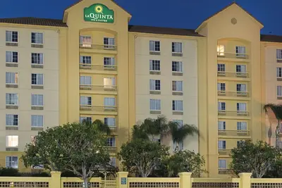 a large yellow building with a sign on it at La Quinta Inn & Suites by Wyndham Ontario Airport in Ontario