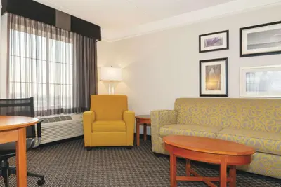 a hotel room with a couch and a chair and a table at La Quinta Inn & Suites by Wyndham Ontario Airport in Ontario