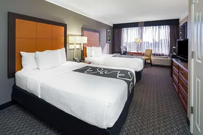 a hotel room with two beds and a television at La Quinta by Wyndham Buena Park in La Palma