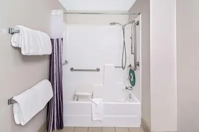 a bathroom with a shower and a white bath tub at La Quinta by Wyndham Buena Park in La Palma