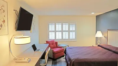 a hotel room with a bed and a desk and a chair at Del Mar Motel in Rosemead