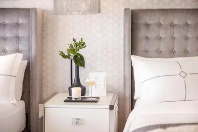 a bedroom with a bed and a nightstand with a plant on it at Huntley Santa Monica Beach in Los Angeles