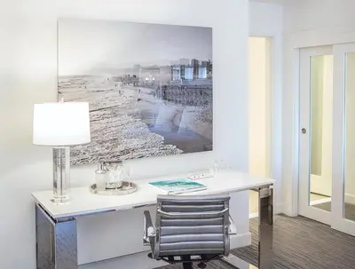 a desk with a lamp and a picture on the wall at Huntley Santa Monica Beach in Los Angeles