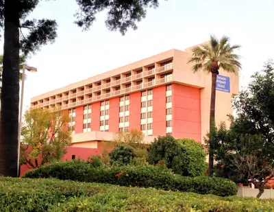 a building with a palm tree in front of it at Ontario Airport Hotel & Conference Center in Ontario
