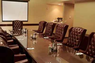 a conference room with a long table and leather chairs at Ontario Airport Hotel & Conference Center in Ontario
