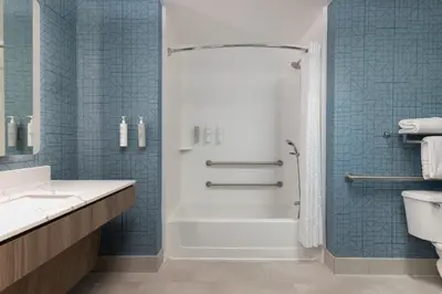 a bathroom with a tub and a shower with blue tiles at Homewood Suites by Hilton Ontario Rancho Cucamonga in Rancho Cucamonga